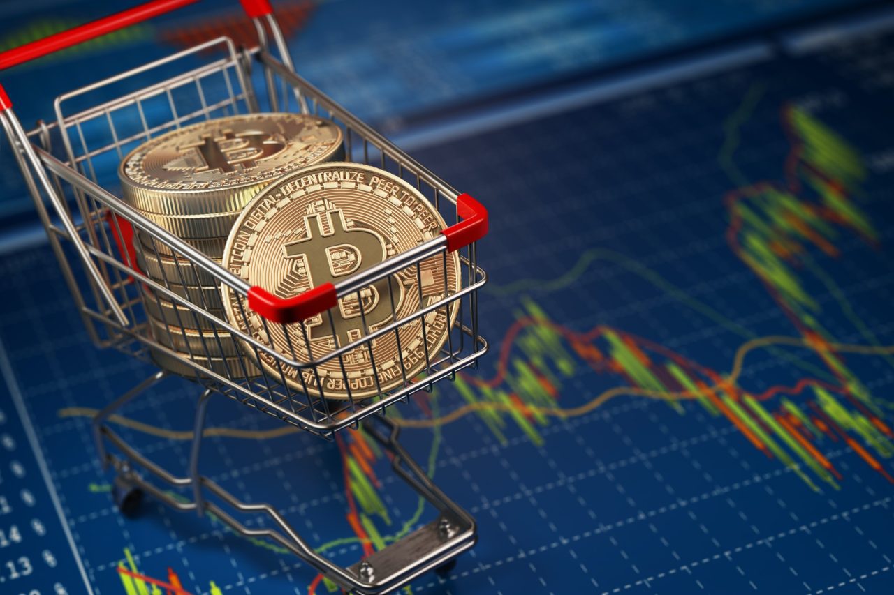 Bitcoin BTC coins in the shopping cart on the financial diagram.